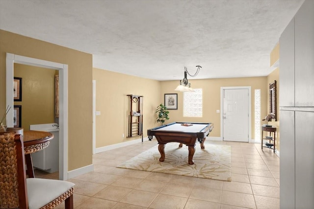 game room with light tile patterned floors, billiards, baseboards, and a textured ceiling