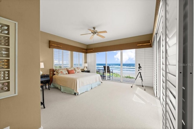 bedroom with access to exterior, multiple windows, a water view, and carpet floors