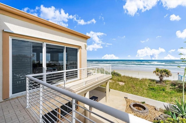 balcony with a water view and a view of the beach