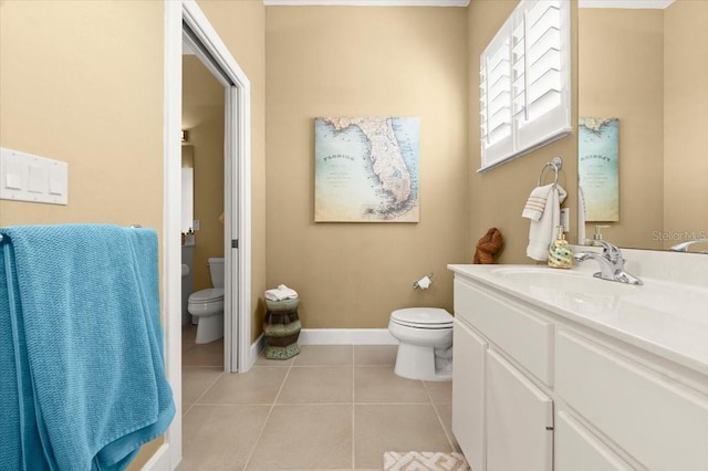 bathroom with baseboards, vanity, toilet, and tile patterned floors