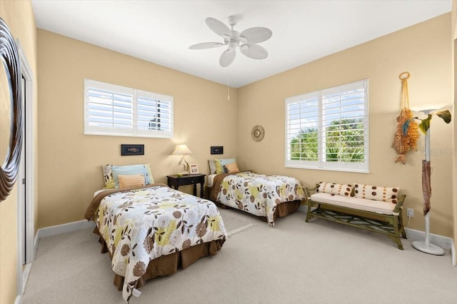 bedroom with carpet floors, multiple windows, baseboards, and a ceiling fan