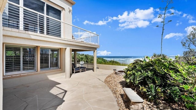 view of patio featuring a water view and a balcony