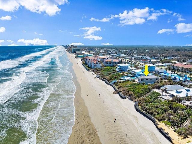 birds eye view of property with a water view and a beach view