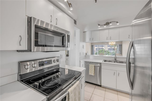 407 Bouchelle Dr Unit 205, New Smyrna Beach, FL 32169 - kitchen featuring white cabinets, appliances with stainless steel finishes, light countertops, a sink, and light tile patterned flooring