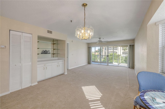 407 Bouchelle Dr Unit 205, New Smyrna Beach, FL 32169 - living room with baseboards, ceiling fan with notable chandelier, visible vents, and light colored carpet
