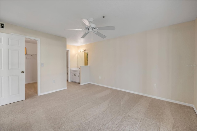 407 Bouchelle Dr Unit 205, New Smyrna Beach, FL 32169 - unfurnished bedroom with connected bathroom, baseboards, a closet, carpet, and a walk in closet