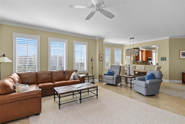 living area featuring light tile patterned floors, ceiling fan with notable chandelier, crown molding, and baseboards