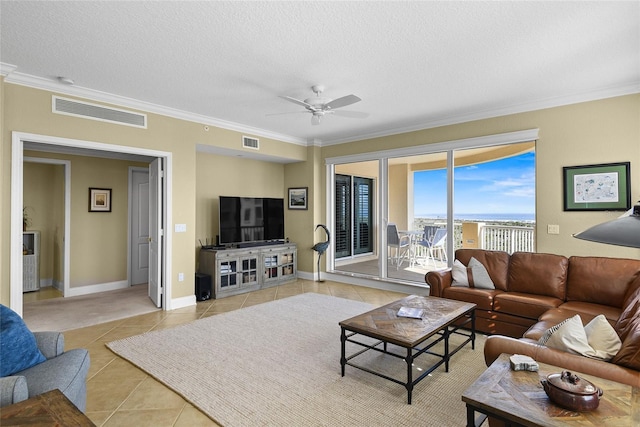 living area featuring a textured ceiling, light tile patterned flooring, visible vents, and ceiling fan