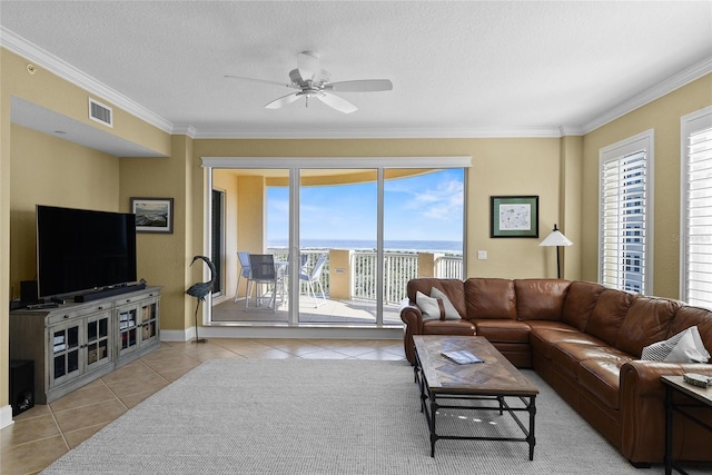 tiled living room featuring visible vents, a textured ceiling, a ceiling fan, and crown molding