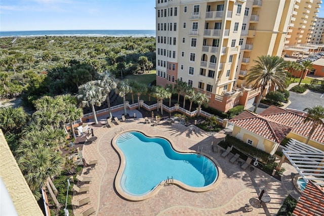 pool featuring a patio and a water view