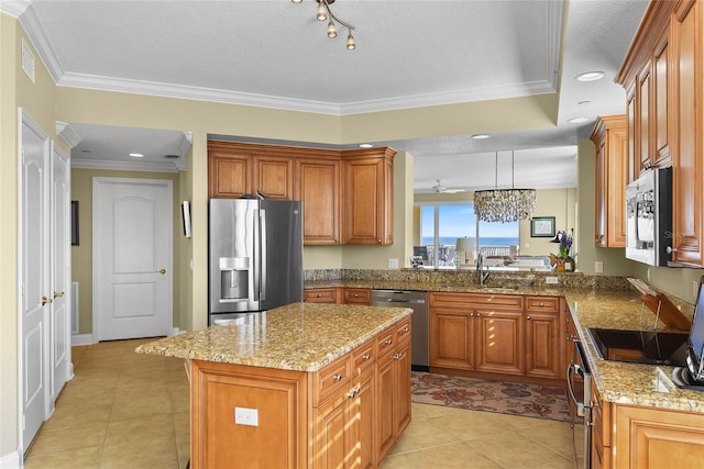 kitchen with brown cabinets, light stone counters, a kitchen island, and stainless steel appliances