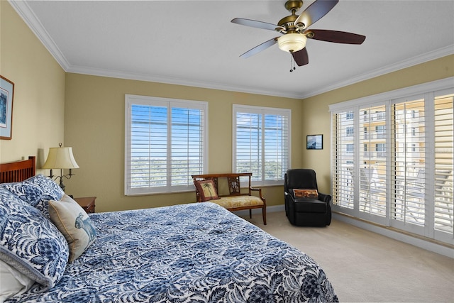 carpeted bedroom featuring baseboards, crown molding, and ceiling fan