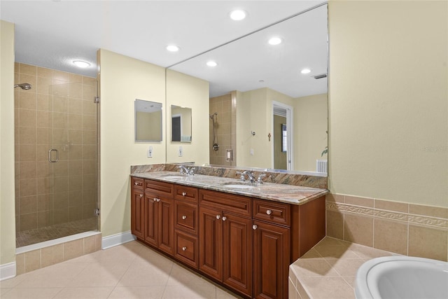 full bath with a shower stall, double vanity, tile patterned floors, and a sink