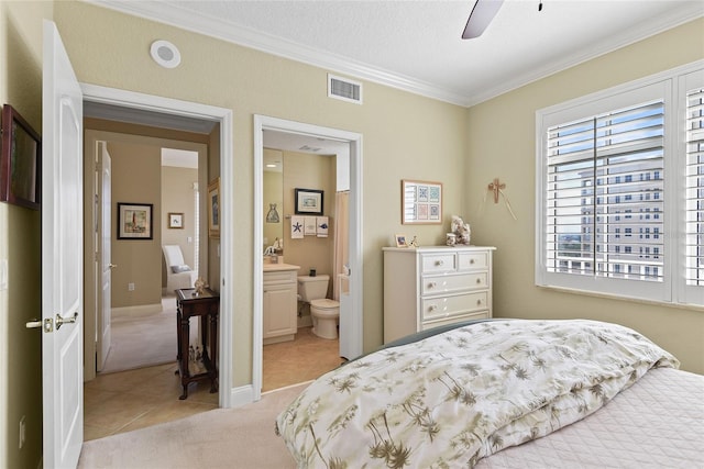 bedroom with visible vents, light carpet, ornamental molding, connected bathroom, and light tile patterned floors