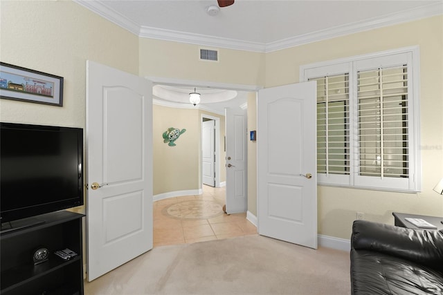 sitting room with light tile patterned floors, visible vents, baseboards, ornamental molding, and light colored carpet