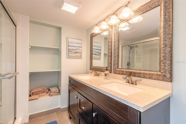 bathroom featuring tile patterned flooring, a sink, a shower stall, and double vanity