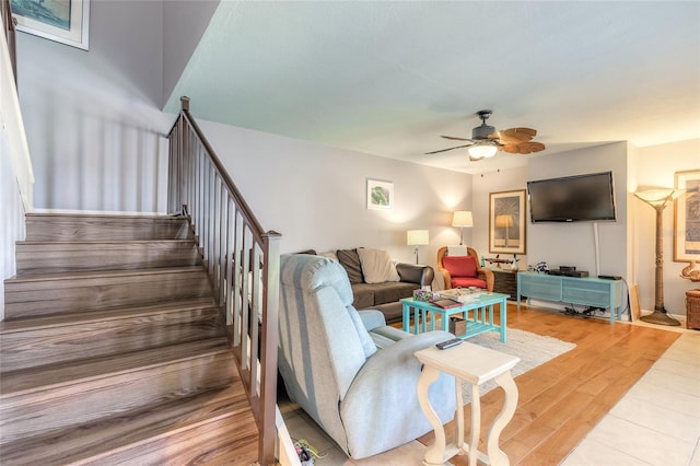 living room featuring ceiling fan, stairway, and light wood-type flooring