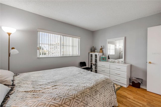 bedroom with light wood-style flooring and a textured ceiling