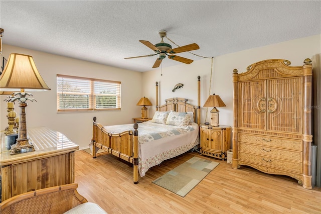 bedroom featuring light wood-type flooring, ceiling fan, and a textured ceiling