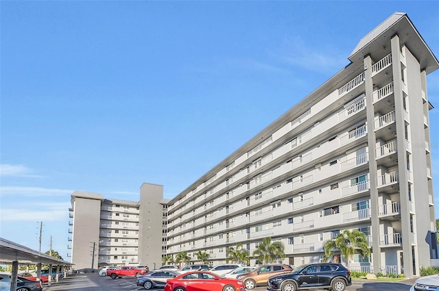 view of building exterior with uncovered parking and a city view