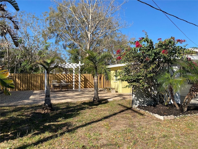 view of yard featuring a pergola, fence, and a patio