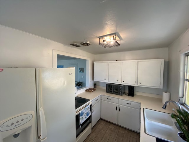 kitchen featuring a sink, dark wood-style flooring, light countertops, white appliances, and white cabinetry