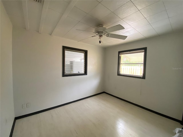 empty room with ceiling fan, baseboards, and wood finished floors