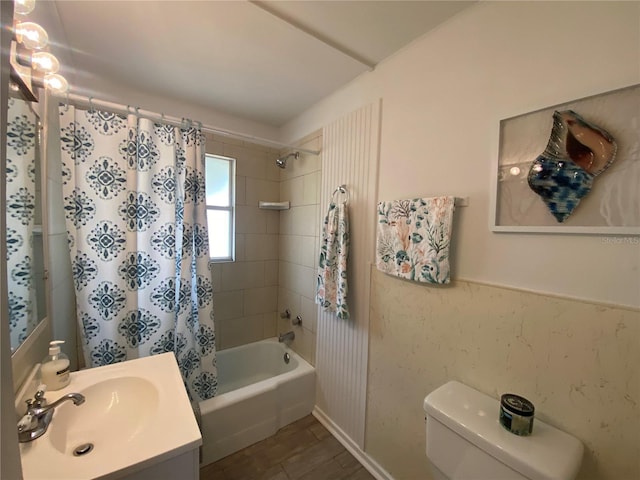 full bath featuring vanity, shower / tub combo with curtain, a wainscoted wall, toilet, and wood finished floors
