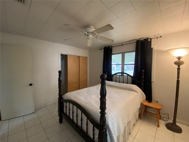 bedroom featuring a closet, light tile patterned floors, and a ceiling fan
