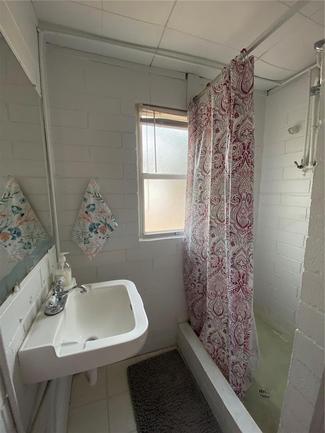 bathroom featuring a shower stall, a sink, and tile patterned flooring