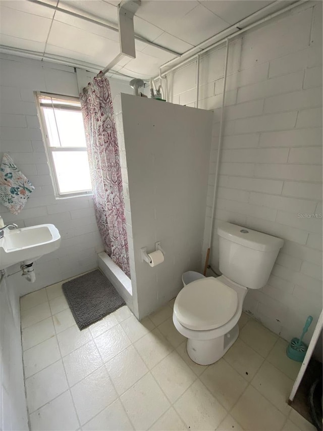bathroom with toilet, tile patterned floors, a sink, and a shower stall
