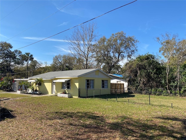 exterior space featuring fence, an attached carport, and a lawn