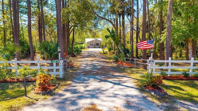 view of street featuring a gated entry and driveway