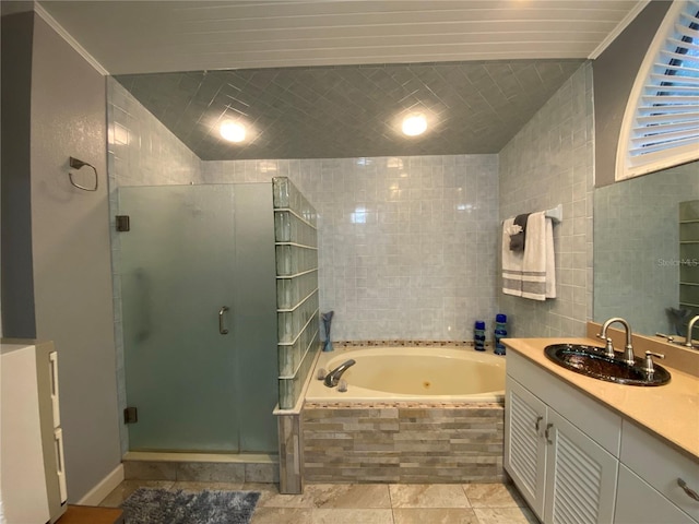 full bathroom featuring a tub with jets, a shower stall, and tile walls