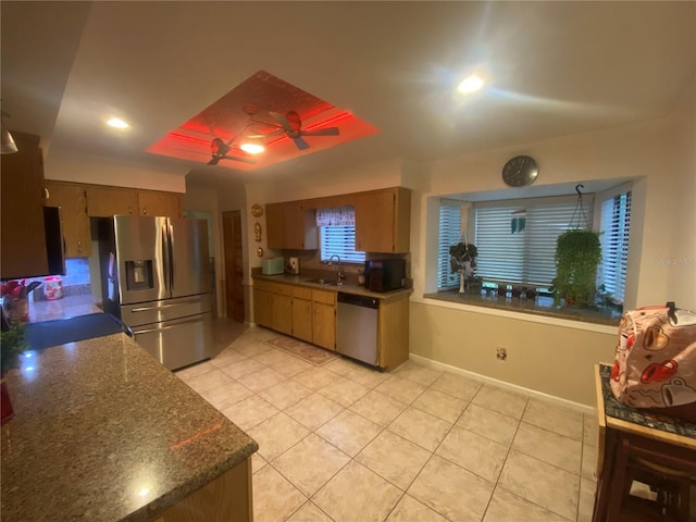 kitchen featuring light tile patterned floors, a sink, ceiling fan, stainless steel appliances, and dark countertops