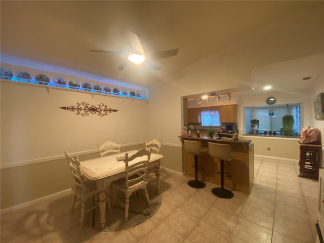 dining room with vaulted ceiling, light tile patterned flooring, baseboards, and ceiling fan