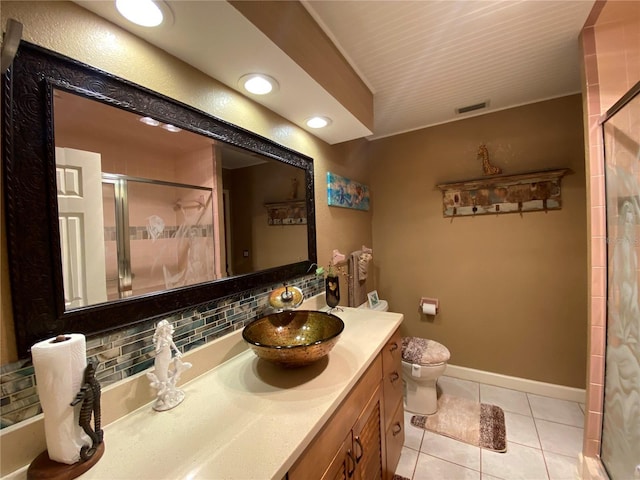 full bathroom with a stall shower, backsplash, tile patterned flooring, baseboards, and vanity