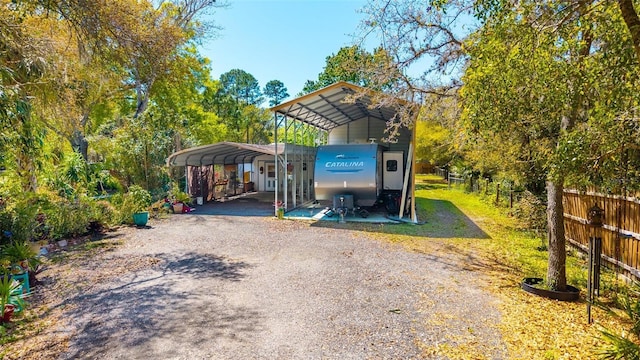 exterior space with a detached carport, fence, and driveway