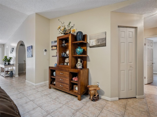 1370 Jane Lacey Ln, New Smyrna Beach, FL 32168 - hall featuring arched walkways, a textured ceiling, light tile patterned floors, and baseboards