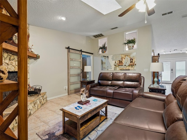 1370 Jane Lacey Ln, New Smyrna Beach, FL 32168 - living room with a ceiling fan, a barn door, light tile patterned floors, a textured ceiling, and vaulted ceiling