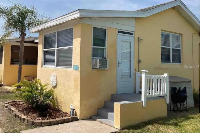 exterior space featuring cooling unit and stucco siding