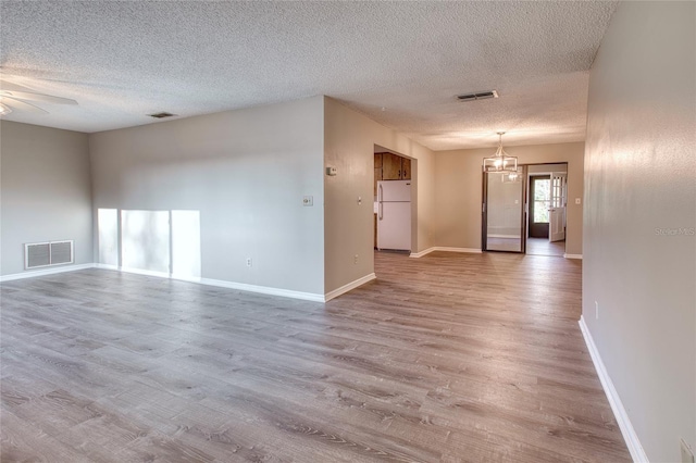 unfurnished room featuring baseboards, visible vents, and wood finished floors