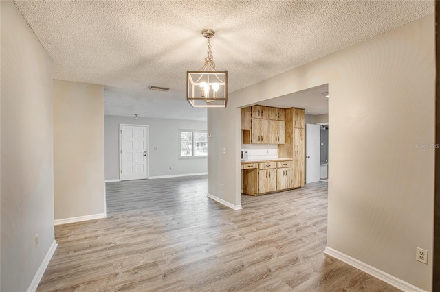 kitchen featuring a notable chandelier, light countertops, visible vents, light wood-style flooring, and baseboards