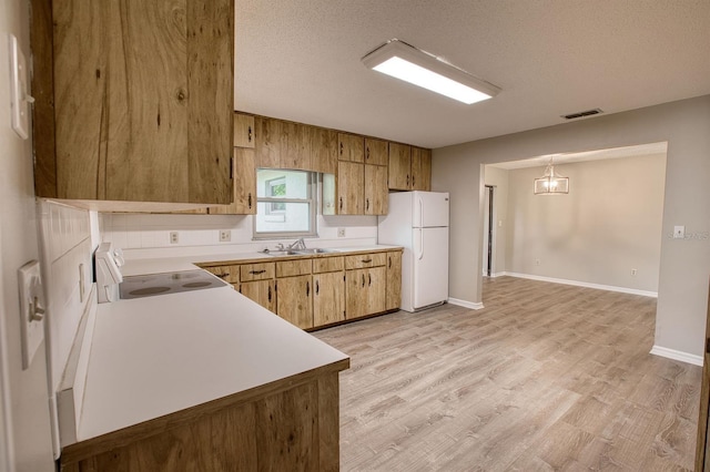 kitchen with electric stove, visible vents, light countertops, freestanding refrigerator, and light wood-type flooring