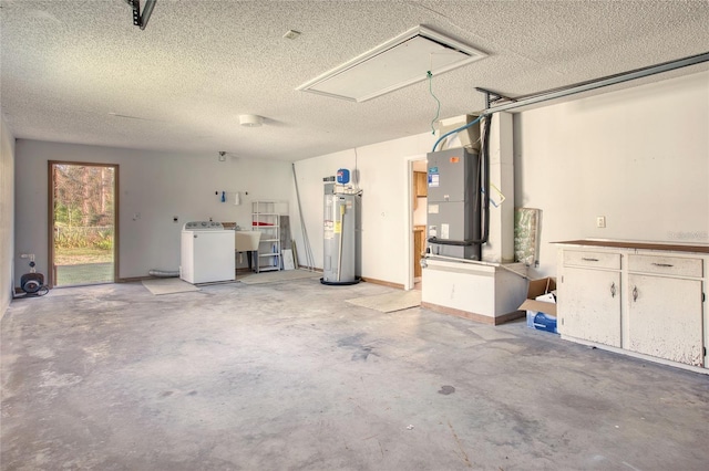 garage featuring heating unit, washer / dryer, and electric water heater