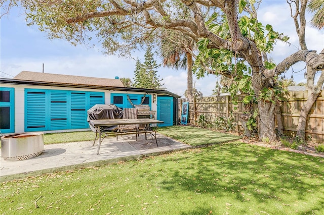 view of yard featuring an outbuilding, fence, and a patio