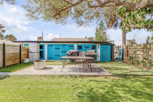 back of property with a yard, a patio area, and a fenced backyard