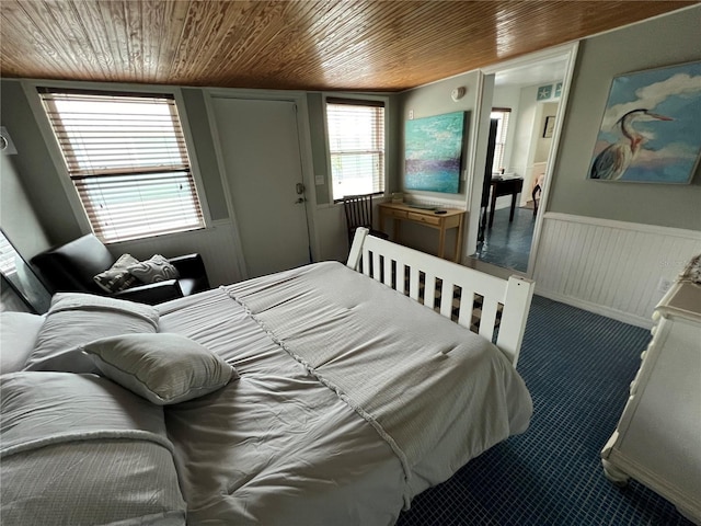 carpeted bedroom with wainscoting and wooden ceiling