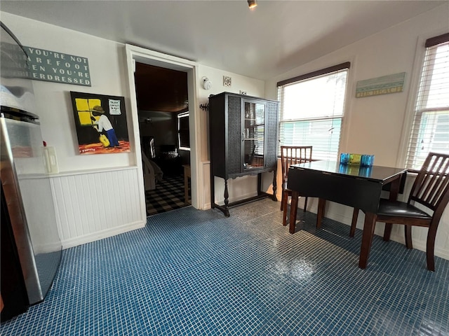 dining area featuring lofted ceiling and dark colored carpet