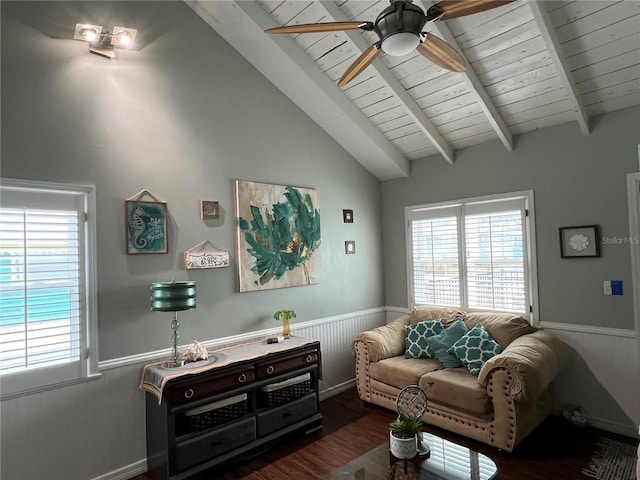 living room featuring plenty of natural light, wainscoting, wood finished floors, and vaulted ceiling with beams